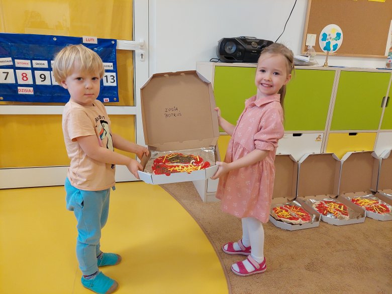 dzieci trzymają pizzę
